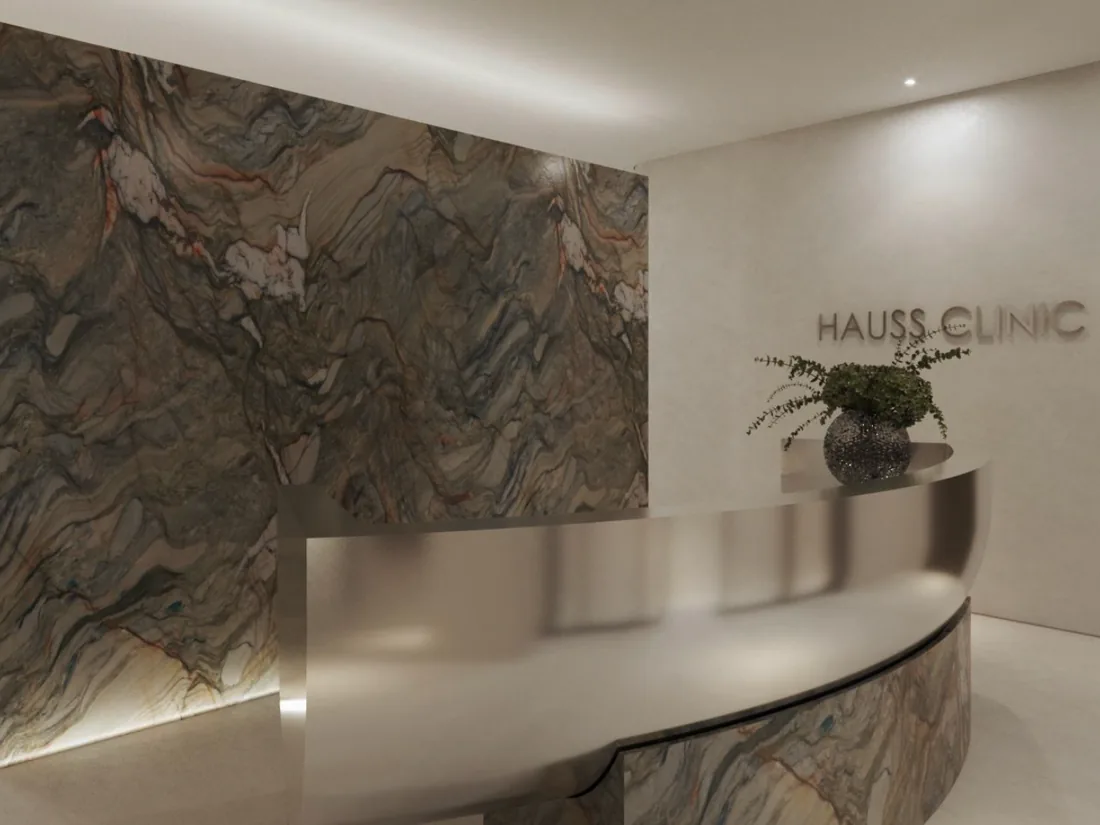 Recepção da Hauss Clinic, com parede de mármore e o nome da clínica